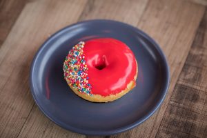 single pink donut on a plate